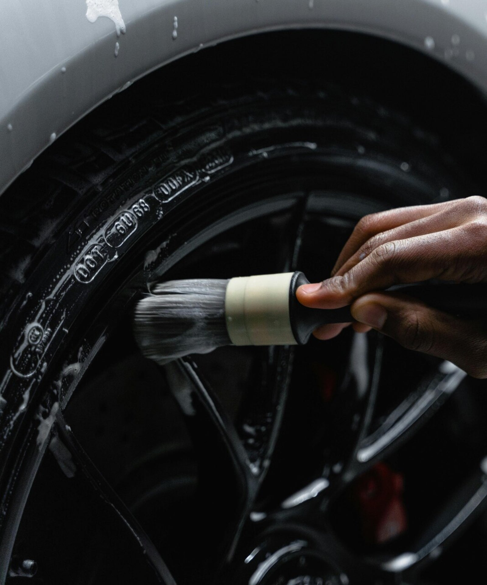 Nettoyage précis d’une jante lors d’un detailing automobile